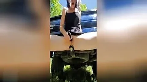 Horny girl masturbates in front of her car